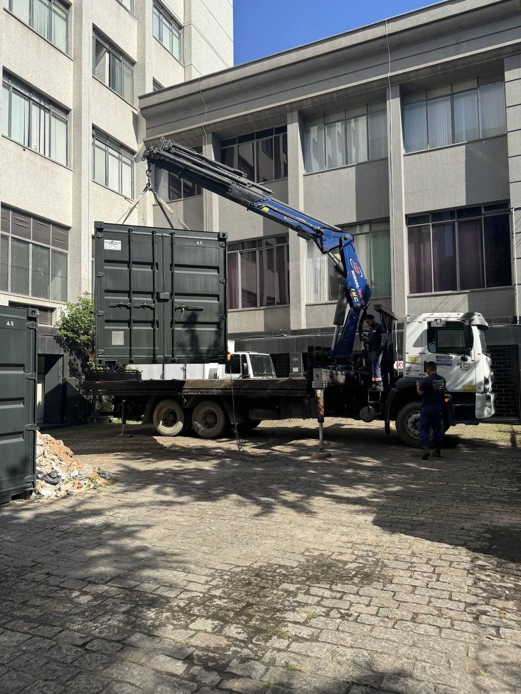 Caminhão munck içando materiais para a cobertura do fórum