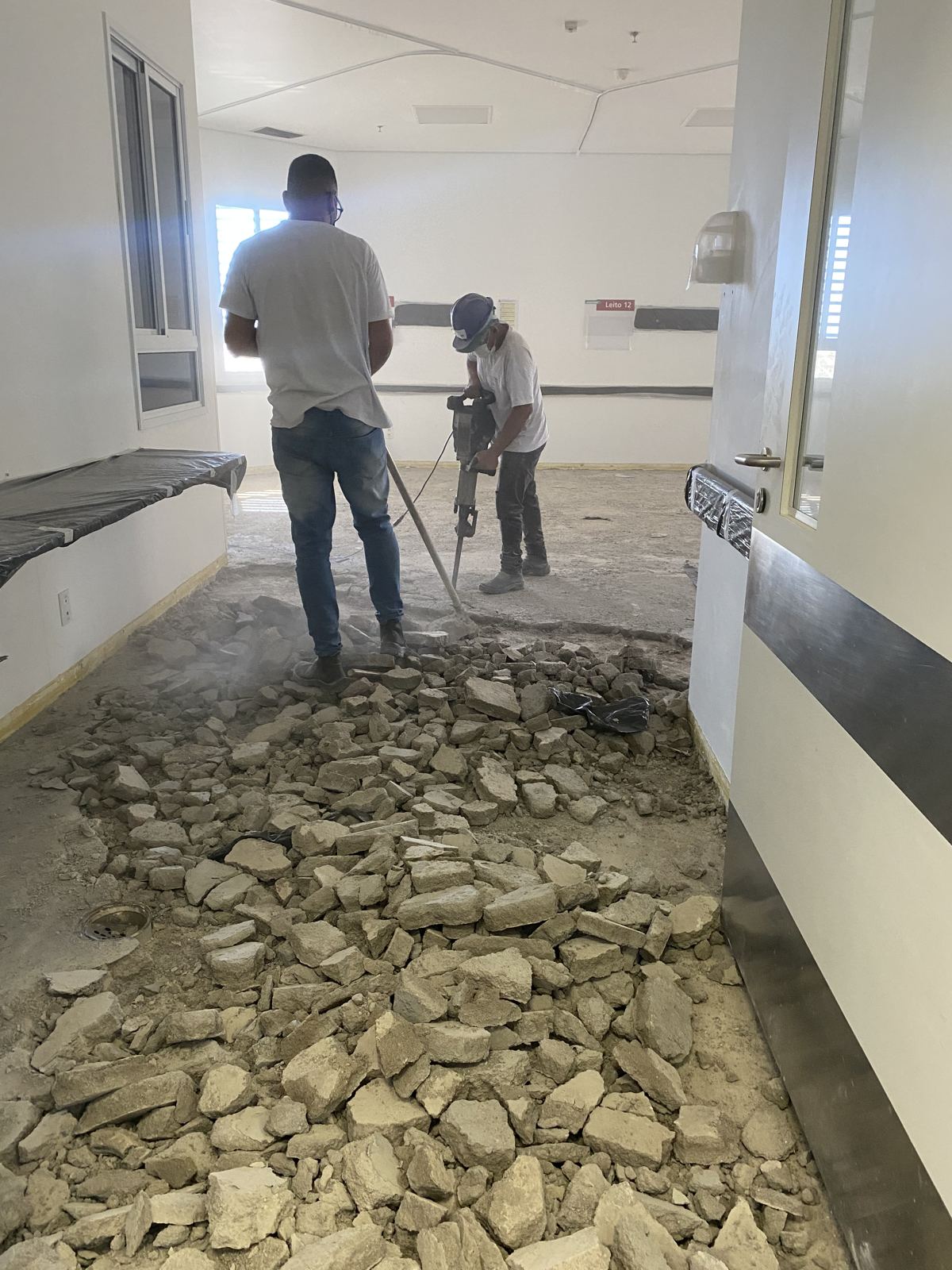 Equipe demolindo o contrapiso antigo