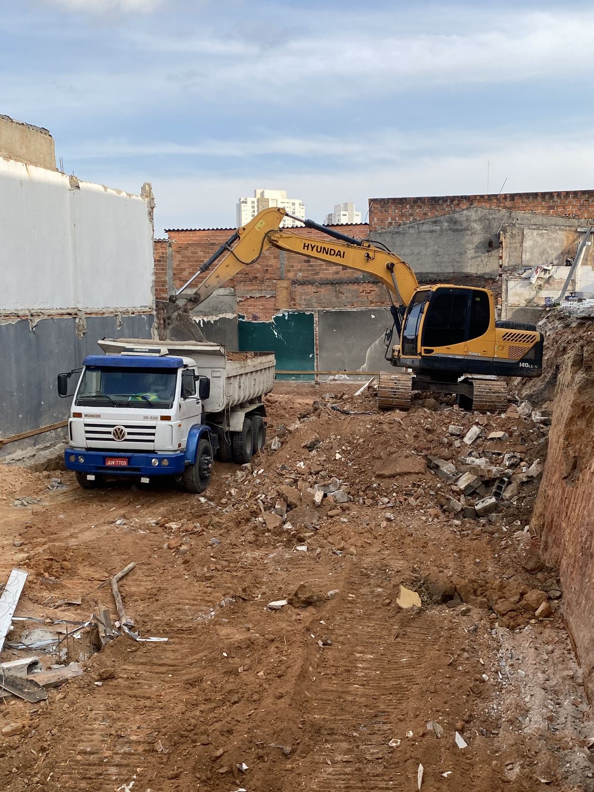 Escavação do terreno com retroescavadeira e caminhão